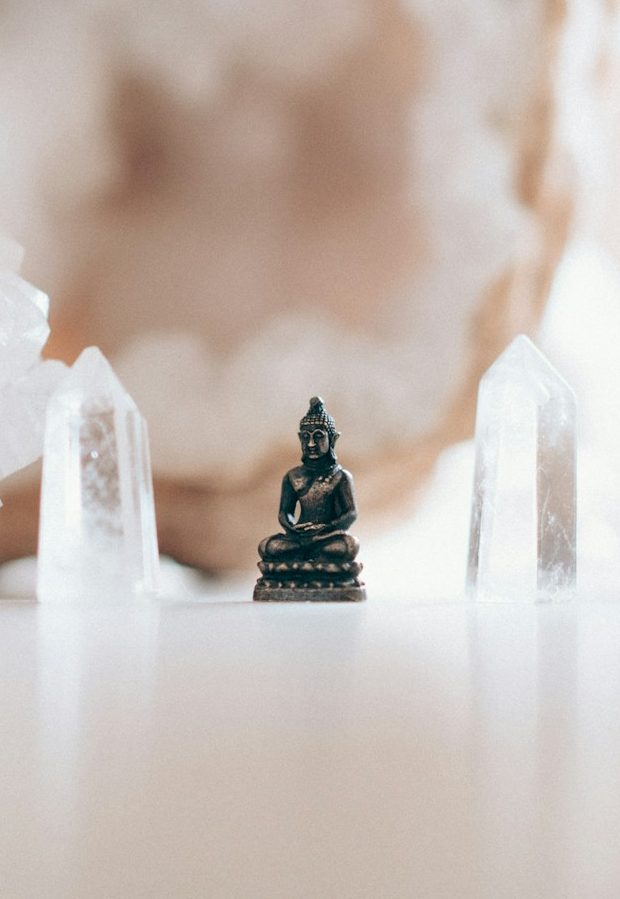 Friedliche Landschaft mit einem Kristall über einem Gewässer und sanften Steinen umgeben.